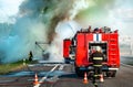 fire engine on the highway extinguishes a burning car after an accident Royalty Free Stock Photo