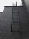 Fire escape on a black brick wall, Emergency exit in case of fire, disaster, earthquake
