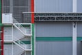 White staircase with conveyor pipeline on factory office building wall