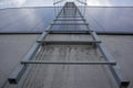 Fire escape on the industrial building above, bottom view. Stainless steel handrails, roof ladder. Detail view of stairs with