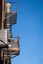 Fire escape rusty stairs and ladder, in metal, on a typical North American old brick building from Montreal, Quebec, Canada. Royalty Free Stock Photo