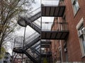Fire escape stairs and ladder, in metal, on a typical North American modern residential brick building from Montreal, Quebec Royalty Free Stock Photo