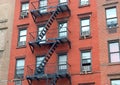 Fire escape stairway on exterior of red brick walkup apartment building