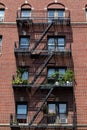 Fire Escapes with Potted Plants on an Old Brick Apartment Building in Astoria Queens New York Royalty Free Stock Photo