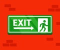 Fire evacuation sign. The safe exit sticker hangs on a brick wall.