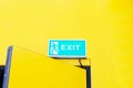 Fire EXIT green emergency exit sign Attached to top of yellow background door office. Royalty Free Stock Photo