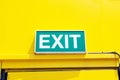 Fire EXIT green emergency exit signs Attached to top of yellow background door office. Royalty Free Stock Photo