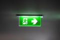 Fire exit sign light box is hung on the ceiling in hotel walk way Royalty Free Stock Photo
