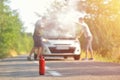 Fire extinguisher against car incident on the road with smoke on Royalty Free Stock Photo