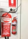 A fire extinguisher, fire blanket and red and white signs attached to the wall of a dwelling