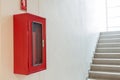 Fire extinguisher cabinet on white wall near staircase Royalty Free Stock Photo