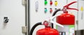 Close-up red fire extinguishers tank with door exit in the building Royalty Free Stock Photo