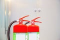 Close-up red fire extinguishers tank with fire escape doorway or door exit in the building concepts of Royalty Free Stock Photo