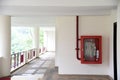 Fire extinguisher and fire hose reel in hotel corridor. Fire hoses rack for use.