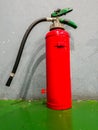 The fire extinguisher on the floor near the wall Royalty Free Stock Photo