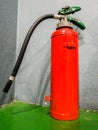The fire extinguisher on the floor near the wall Royalty Free Stock Photo