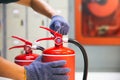 Fire extinguisher has hand engineer checking safety pin on handle of fire extinguishers is fire equipment for protection and Royalty Free Stock Photo
