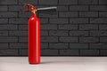 Fire extinguisher near grey brick wall Royalty Free Stock Photo