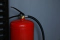 Fire extinguisher near grey wall, closeup. Space for text Royalty Free Stock Photo