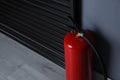 Fire extinguisher near grey wall. Space for text Royalty Free Stock Photo