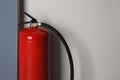 Fire extinguisher near light wall indoors. Space for text Royalty Free Stock Photo