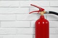 Fire extinguisher near white brick wall. Space for text Royalty Free Stock Photo