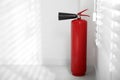Fire extinguisher near white wall. Space for text Royalty Free Stock Photo