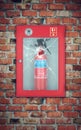 Fire extinguisher in wall box with cracked glass. brick wall Royalty Free Stock Photo