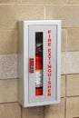 A fire extinguisher in a wall mounted box.