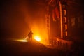 Fire in the factory. Firemen examines the consequences of fire. Human silhouette on fire background Royalty Free Stock Photo