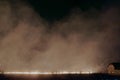 Fire in the field at night, burning grass on the field, the smoke from the burning field Royalty Free Stock Photo