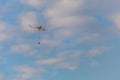 A fire fighter helicopter with a full basket of water flies against a beautiful sky Royalty Free Stock Photo