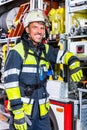 Fire fighter in protective clothes leaning at fire engine Royalty Free Stock Photo