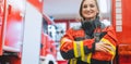 Fire fighter woman standing in front of a fire truck