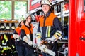 Fire fighters attaching hose at hose laying vehicle Royalty Free Stock Photo