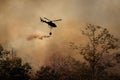 Fire fighting helicopter dropping water onto wildfire