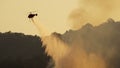 Fire fighting helicopter dropping water onto wildfire