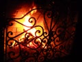 Fire in the fireplace behind a beautiful wrought iron grate with curls. A fire is burning in the fireplace. Night and Royalty Free Stock Photo