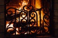 Fire in the fireplace behind the grate Royalty Free Stock Photo