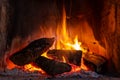 Fire in a fireplace with logs and flames creating a sense of warmth and coziness