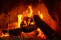 Fire in a fireplace with logs and flames creating a sense of warmth and coziness