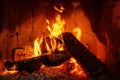 Fire in a fireplace with logs and flames creating a sense of warmth and coziness