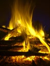 Fire flames of a large pile bonfire on black background