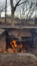 Bonfire with bright red flame in old mangal made from burnt smoky damaged bricks on ground