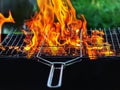 Fire in the grill. The red flames of a campfire make their way through the grill grate Firewood is burning in the backyard barbecu