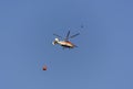 Fire helicopter brings water to fight with the fire. The orange basket with ropes is for transporting the water