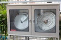 Fire hose cabinet. White hose in the water drawer to extinguish the fire. Hydrant with water hoses and fire extinguish equipment Royalty Free Stock Photo