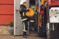 With fire hose in hands. Woman in uniform is at work in department