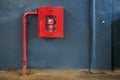 Fire hose in red box. Pipe roll for fire emergency in red metal cabinet on gray painted concrete wall with tiled floor Royalty Free Stock Photo