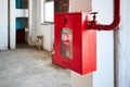 Fire hose in red box. Pipe roll for fire emergency in red metal cabinet on grey whitewashed wall as part of fire Royalty Free Stock Photo